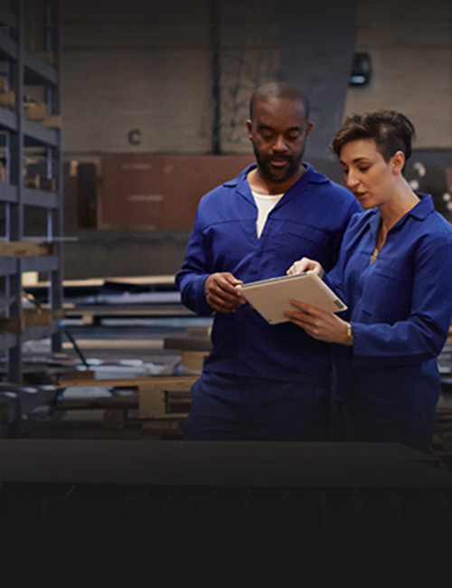 Two employees assembling machinery in a manufacturing plant